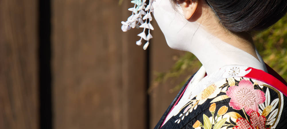 Japanisches Steinbecken mit Bambus-Schöpfkelle und grünen Ahornblättern